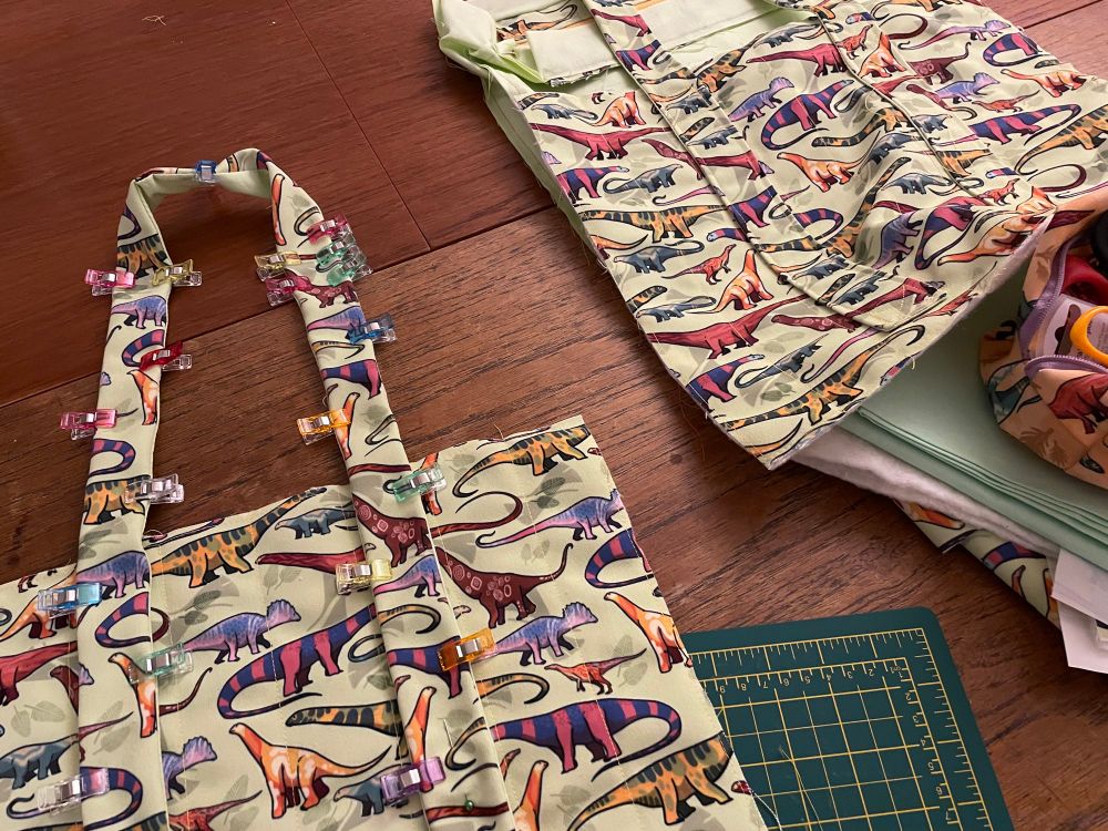 a work in progress photo of a green dinosaur pattered bag