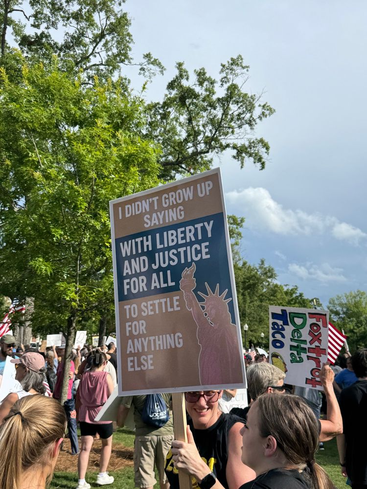 A protest sign that says “I didn’t grow up saying With Liberty and Justice for All to setting for anything else