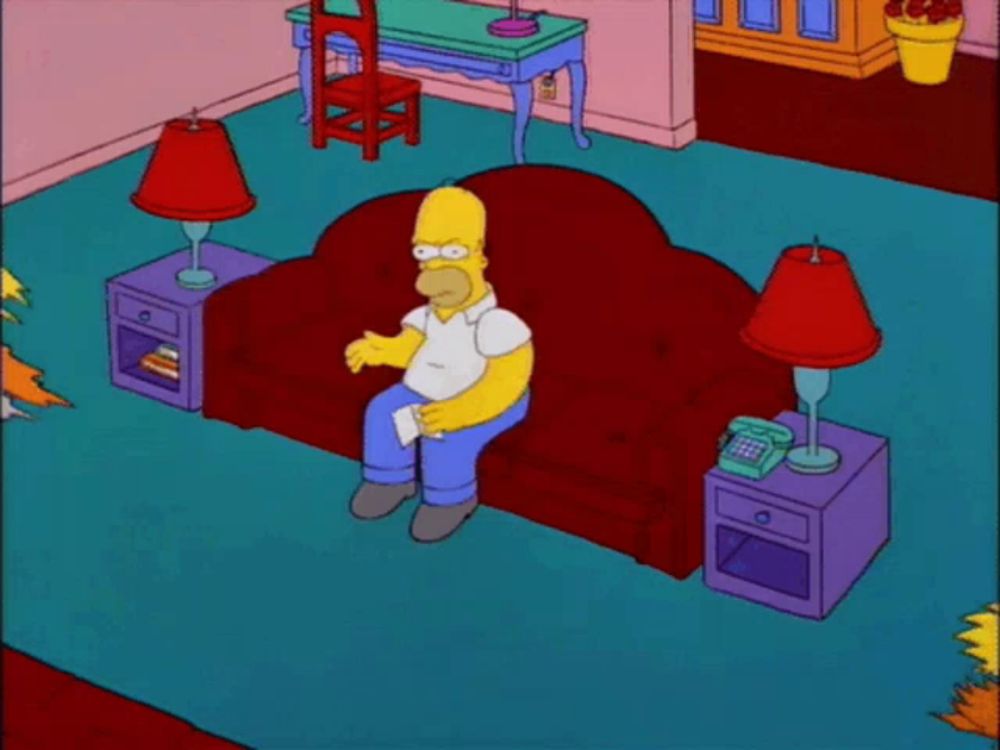 homer simpson from the simpsons is standing in front of a red couch