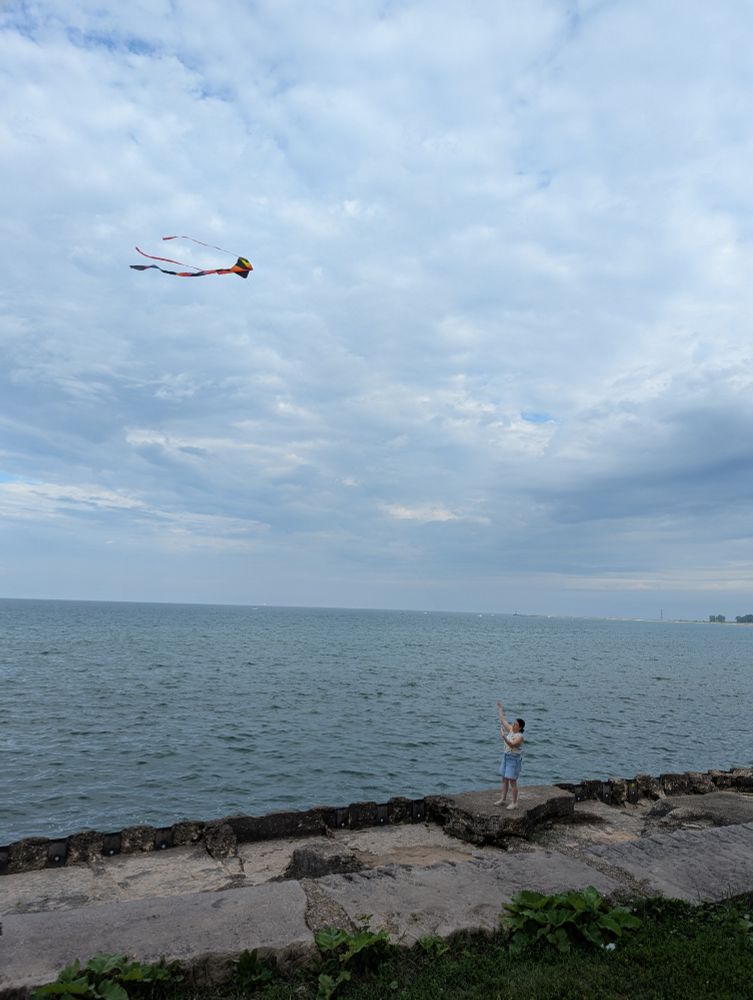 Flying a kite by the edge of the lake