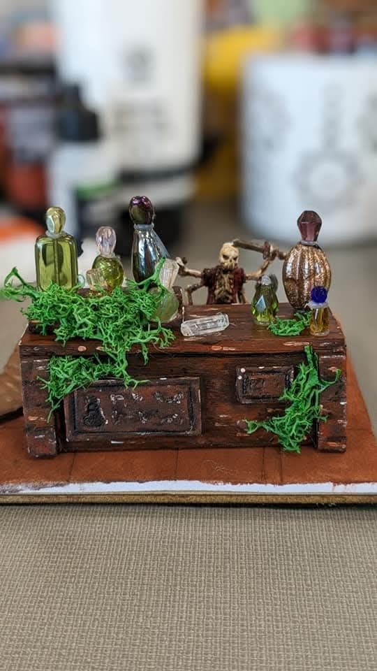 A skeleton mini stands behind a potions counter. The counter is covered in moss and large potion bottles