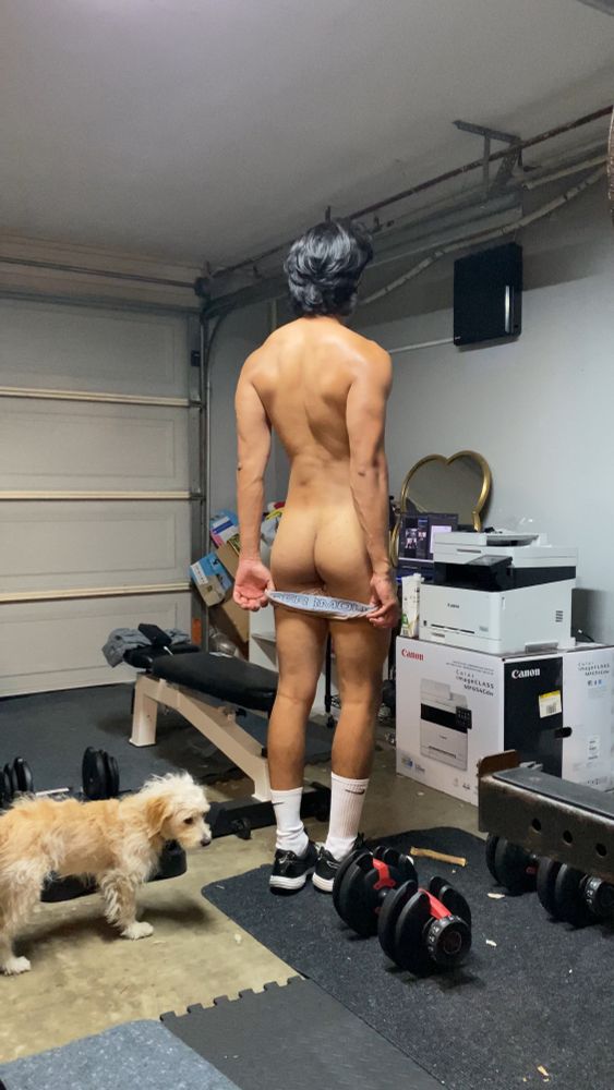 The fag is turned around showing off back muscles and butt because his undies are pulled down 
