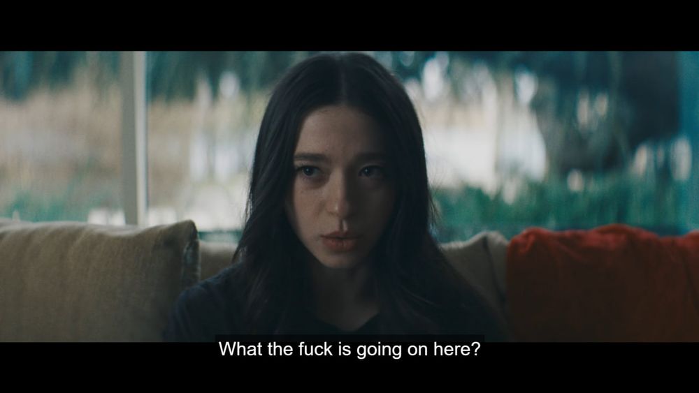 Die Hauptdarstellerin vom Film Anora auf der Couch sitzend, sie sagt "What the fuck is going on here"