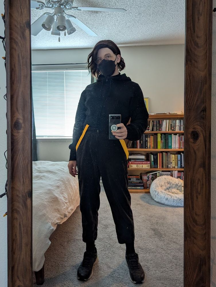 cayce mirror selfie, black shoes black barrel pants black cropped hoodie zipped up, black kn95, yellow suspenders worn down