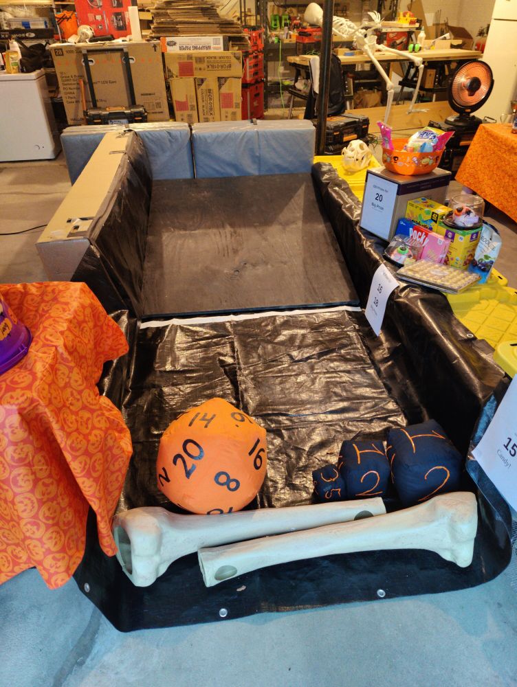Basketball sized pillow 20 sided die on a homemade ramp in a garage.