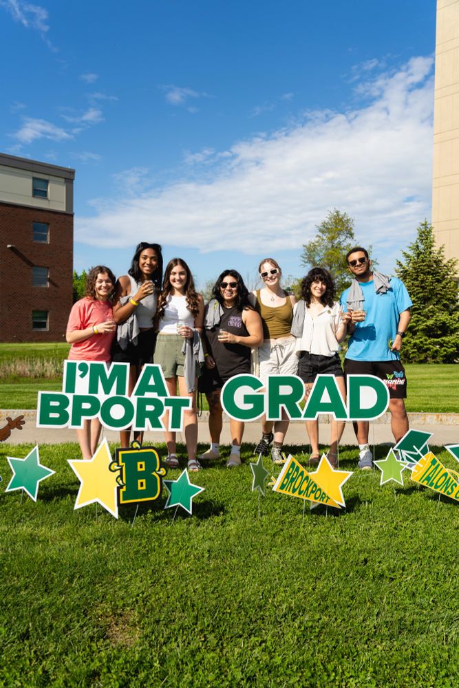 A group of Brockport students with champagne glasses at the Almost Alum Block Party.