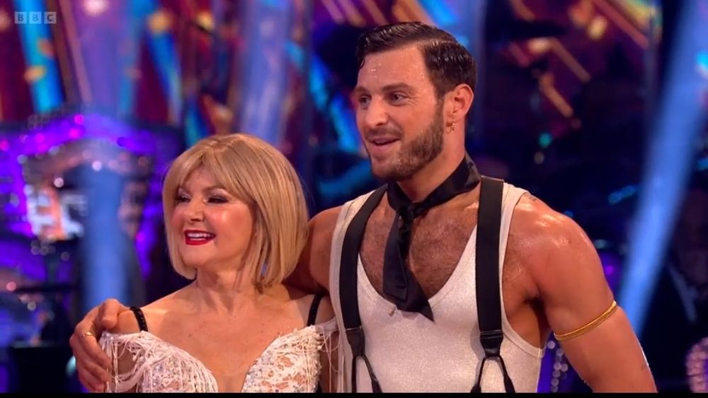 Vito from Strictly, all sweaty, westing a white vest with black braces 