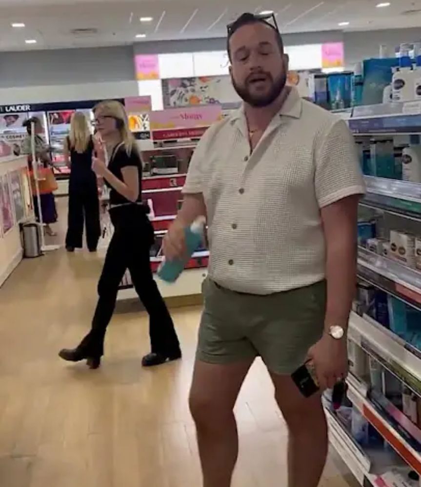 Still image taken from the video in question showing a white man wearing shorts that reach his mid-thigh. (Daisy dukes would expose the bottom of the butt cheek.)