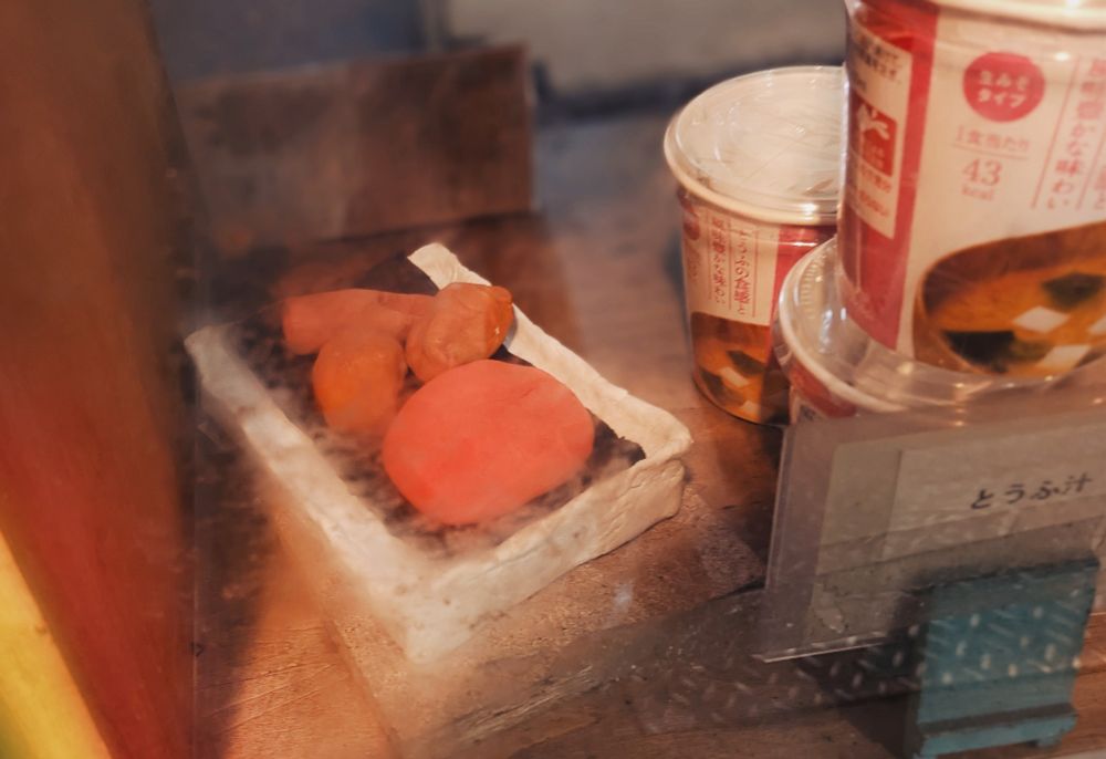 弁当屋のショーケースに、紙粘土で作ったゆるいお弁当が置いてある。