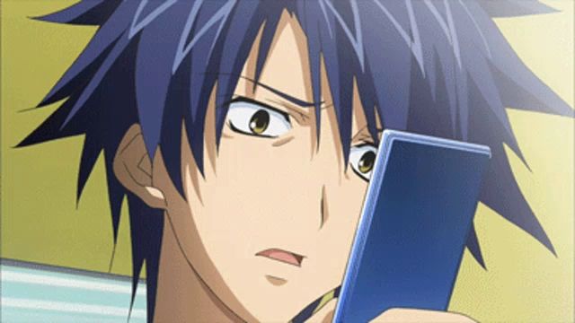 a boy with blue hair is looking at a cellphone