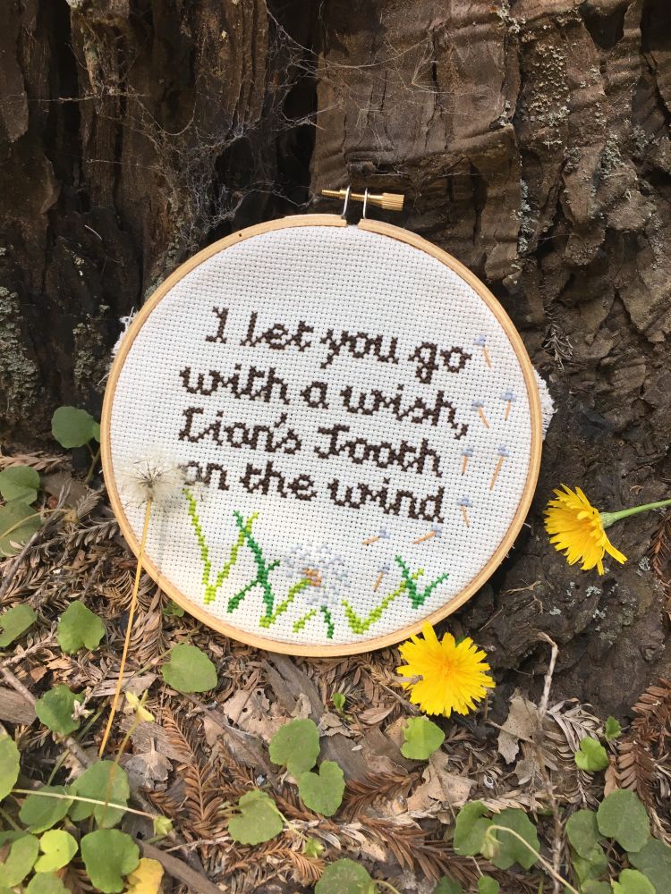 A cross stitch reading I let you go with a wish, lions tooth on the wind with dandelion puffs flying up