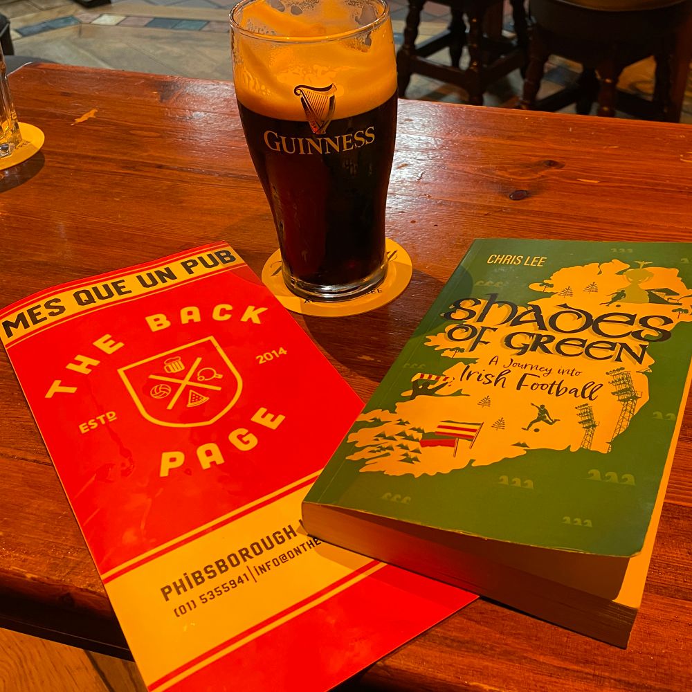 Cover of the mentioned book, menu of ‚The Back Page‘ and an half full glas of Guiness.