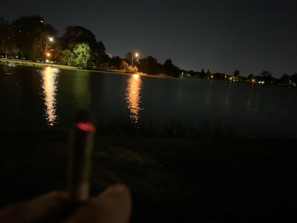 smoking weed by a lake at night