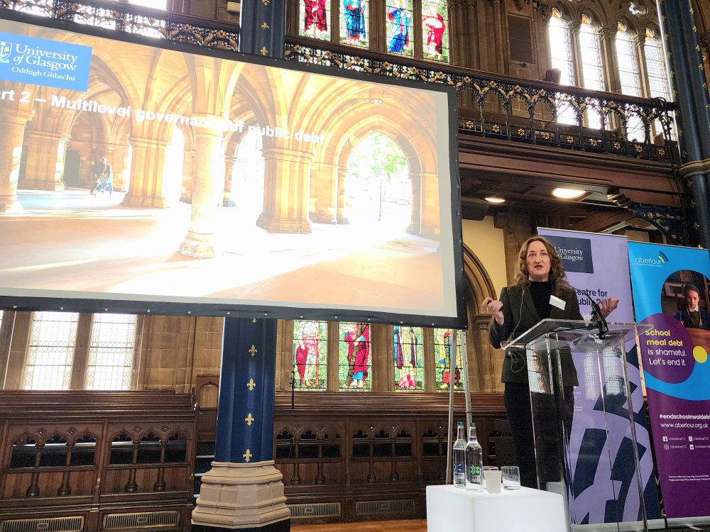 Person speaking at podium in front of presentation screen