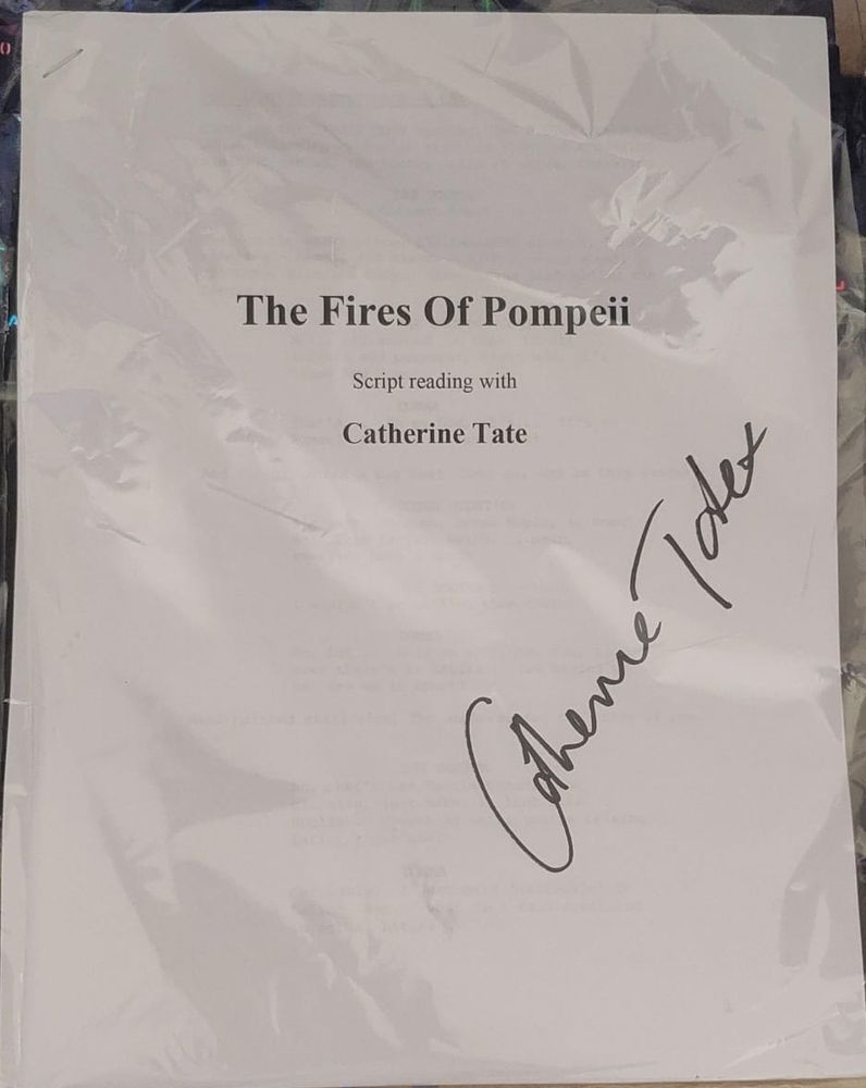 Papel embalado em um saquinho plástico transparente onde se lê:
The Fires of Pompeii 
Scrips reading with
Catherine Tate 

Na diagonal direita está o autógrafo de Catherine Tate.