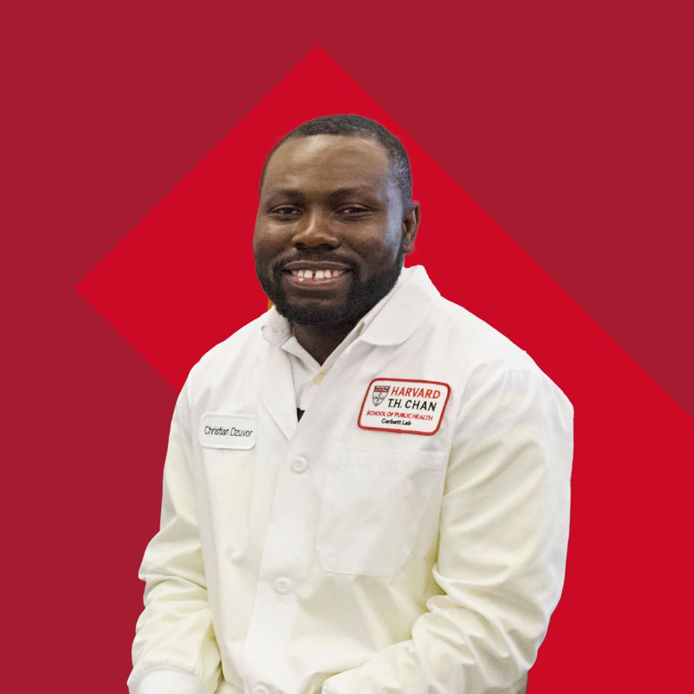Dr. Christian Dzuvor in a white Harvard Chan School lab coat. 