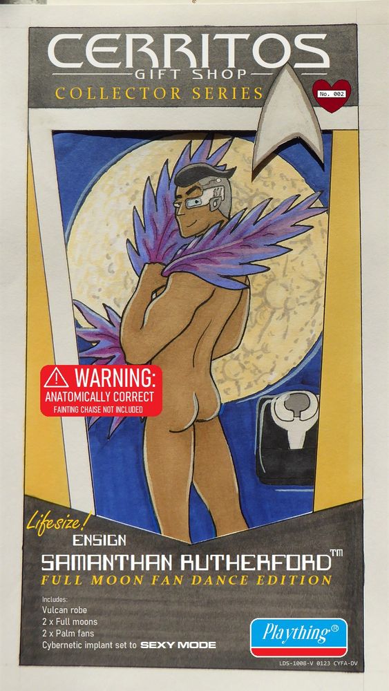 Naked Sam Rutherford holding palm fronds (and with a strategically placed sticker) posing in a human-sized action figure packaging box labelled "Full Moon Fan Dance Edition".