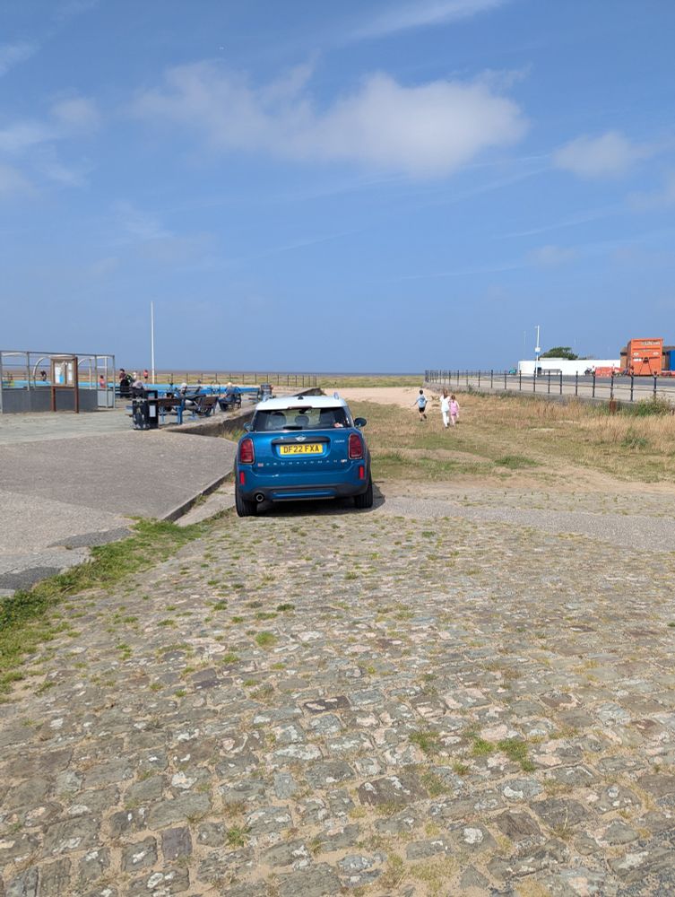 A Mini parked on the actual fucking beach, because apparently the giant promenade of free parking wasn't close enough