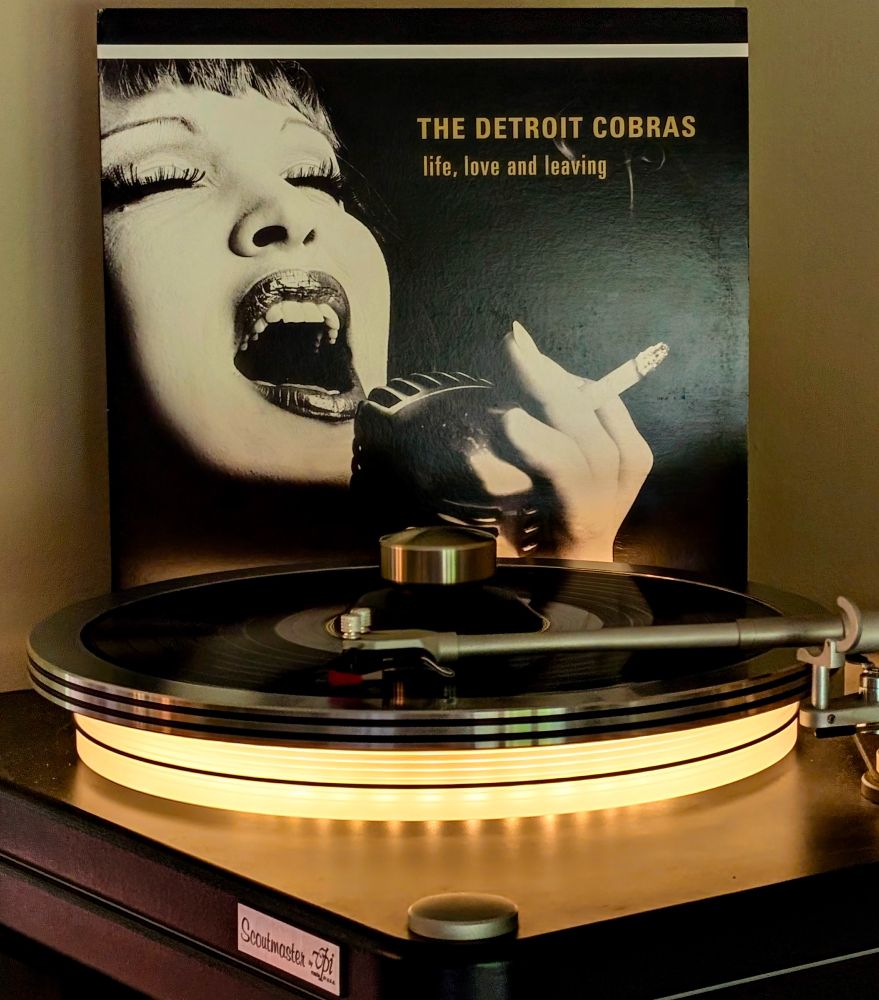 Detroit Cobras 'live, love and leaving' vinyl LP playing on VPI Scoutmaster turntable, platter glowing warm white

Album cover is close up of Nagy singing into a mic, eyes close, cigarette in hand
