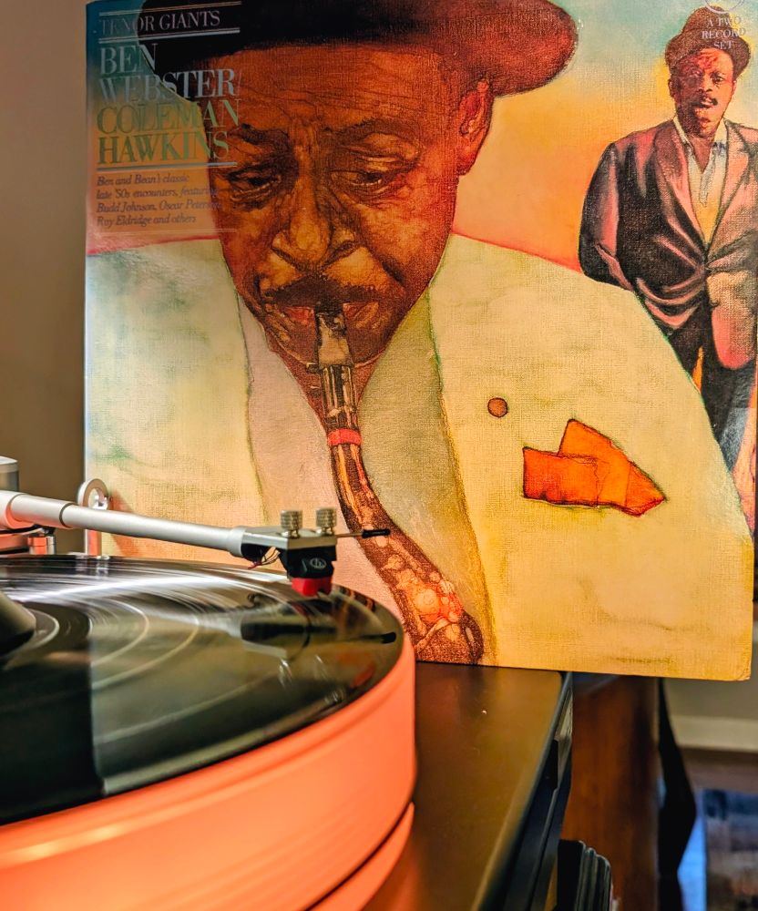 Ben Webster / Coleman Hawkins – Tenor Giants #nowplaying on VPI Scoutmaster turntable, 12-pound acrylic platter glowing orange. Audio Technica AT-VM95ML cartridge.

Cover illustration of one of them wearing a white blazer with orange pocket square playing sax, whole the other stands behind

Selection from Dad's Collection 65
