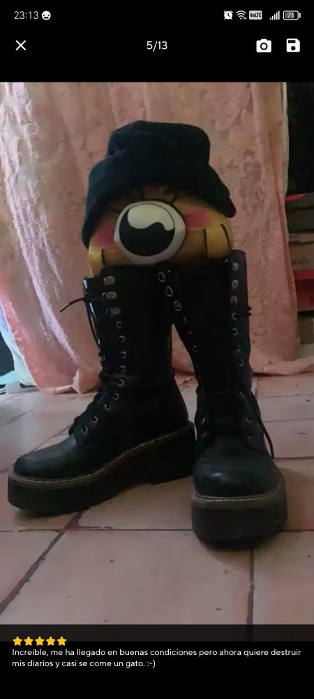 Peluche de Baby Bill con gorro de lana negro y botas que son el doble de grandes que él.