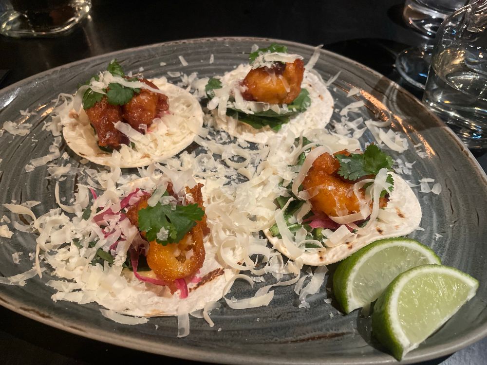 Four langoustine tacos, along with a pair of lime slices.