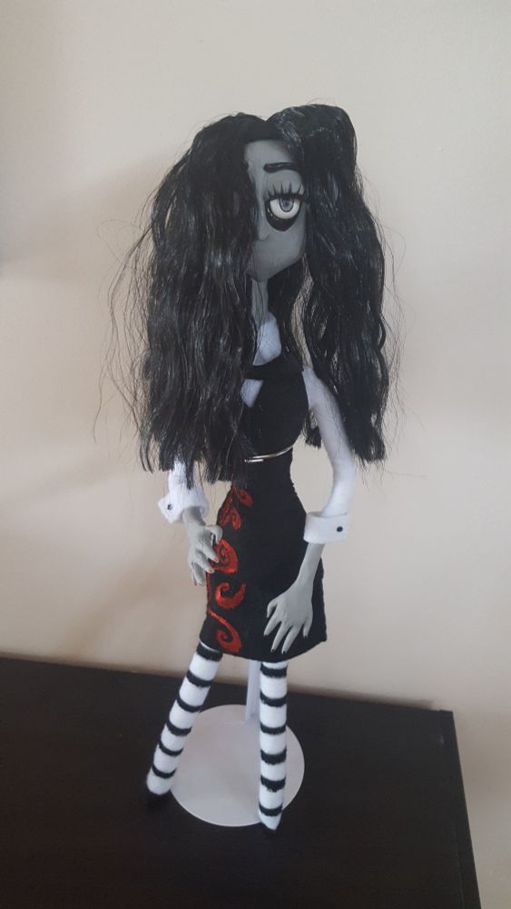 Doll standing on table.