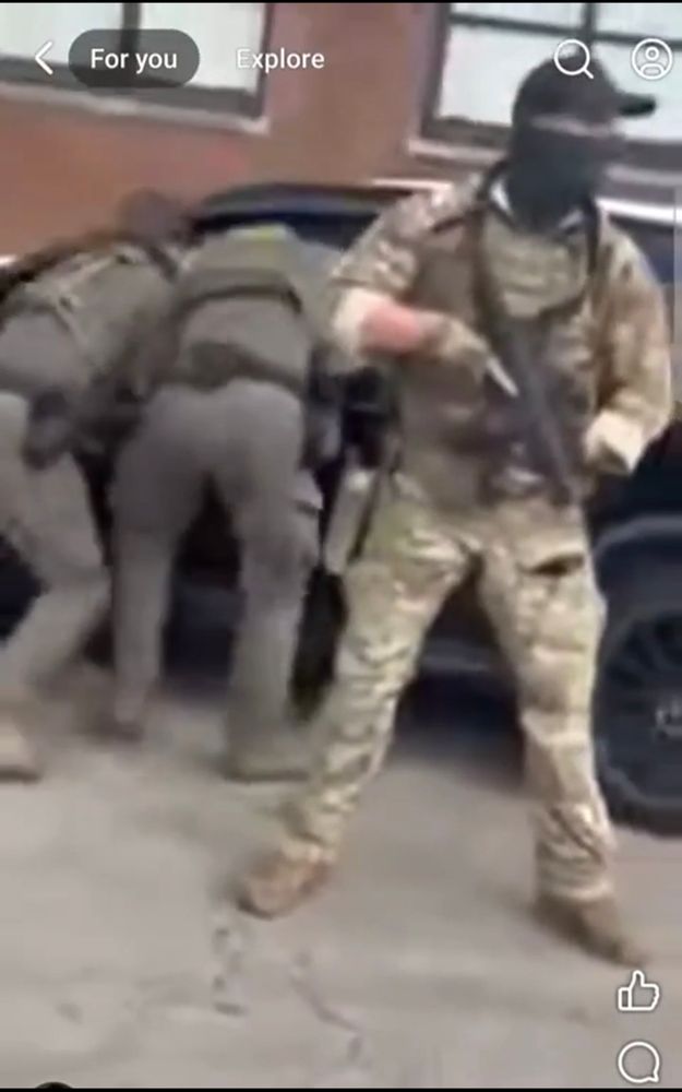 an ice agent holds a 9mm carbine while pulling security for two other officers who are attempting to detain a woman whose car they just ran into while making an illegal u turn in the middle of an intersection, according to the person filming 