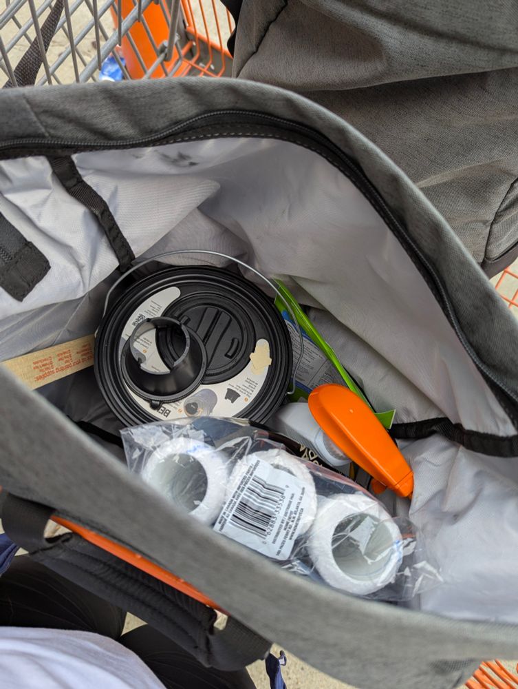 Picture of the contents of one bike pannier. Has a gallon of paint, rollers and miscellaneous house cleaners.