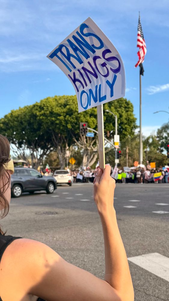 A protester holds a sign that says Trans Kings Only
