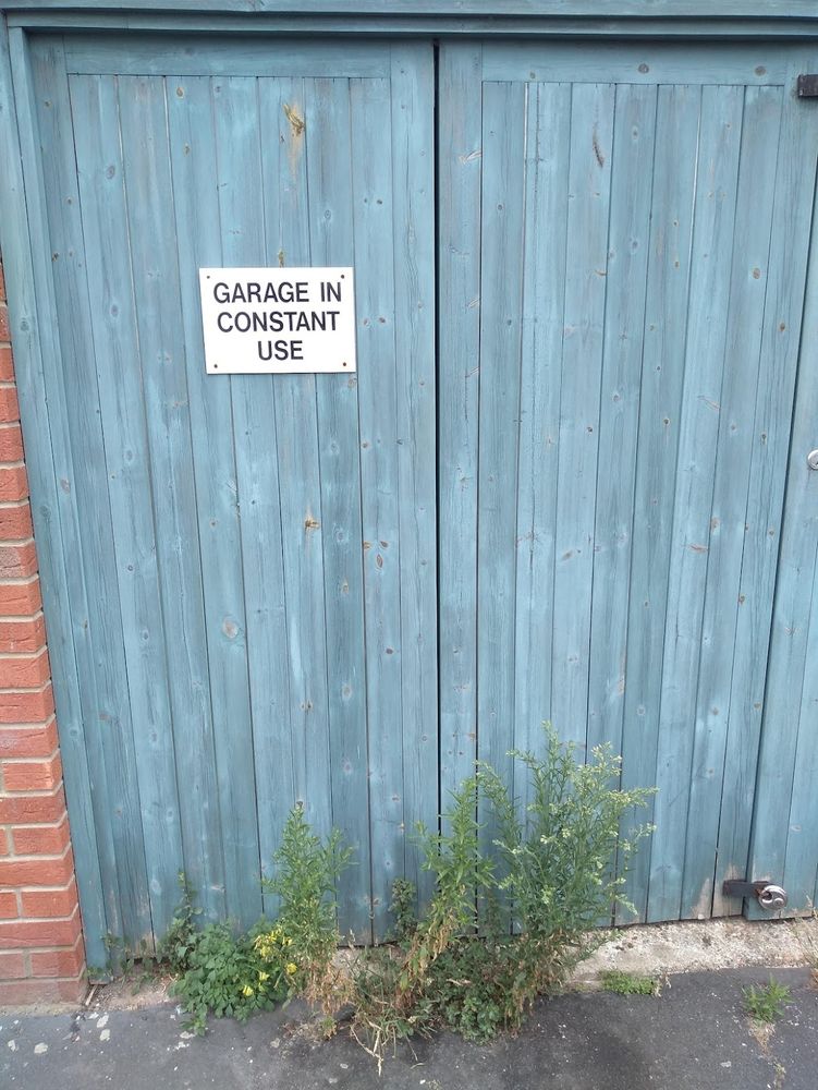 Closed garage doors 'in constant use' yet with weeds growing prolifically in front of them