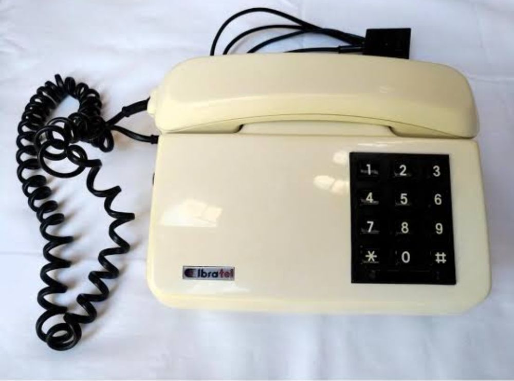 Telefone fixo, meio amarelado, com teclas