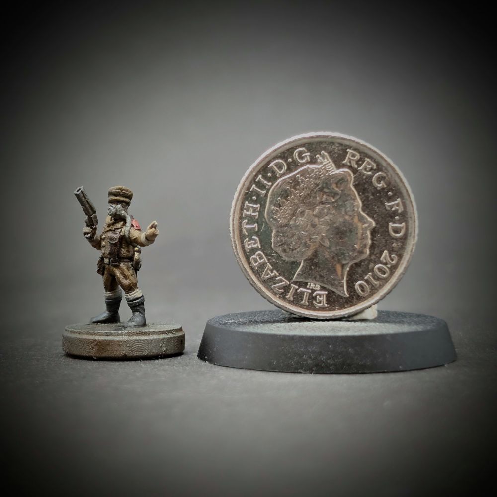 The same miniature compared to a British 5 pence piece stuck to a standard miniature base. The coin is taller than the miniature by a head or more.