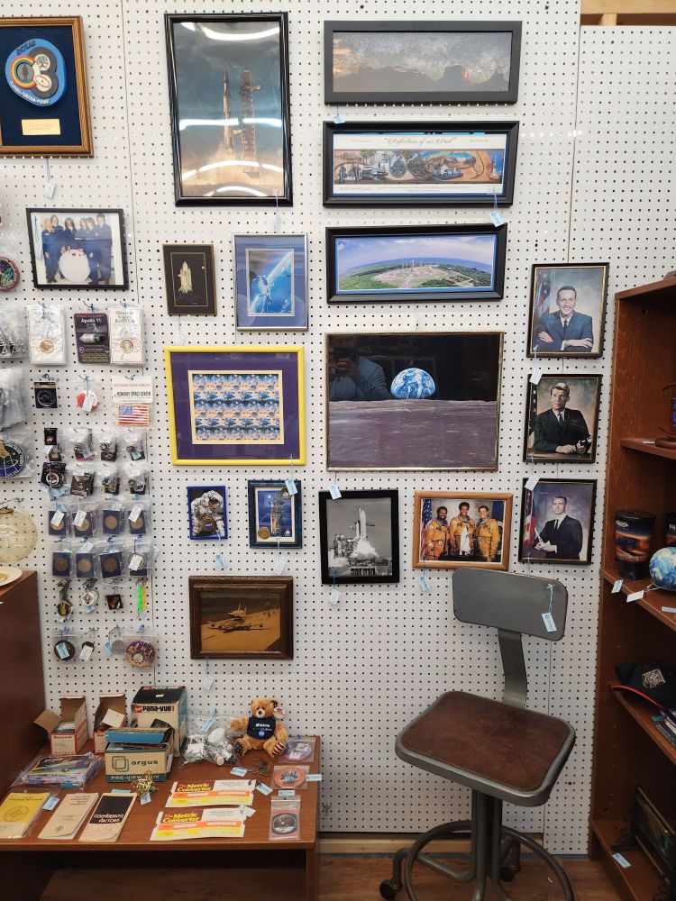 Photo of left side of antique mall booth that highlights various framed space wall photos.