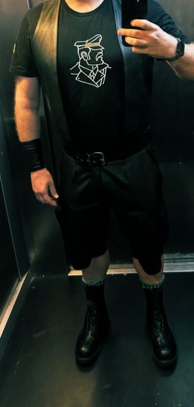Wearing leather shorts and waistcoat & wrist cuff (on my left), boots and a black T-shirt with a motif of a leatherman