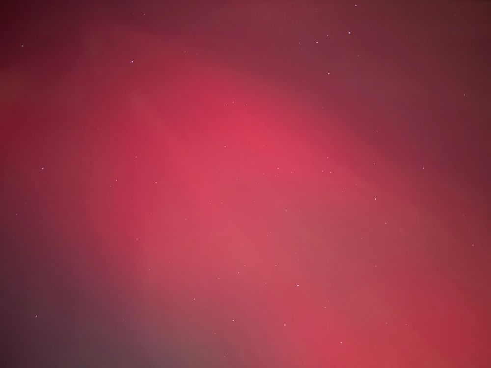 A vivid red aurora filling the entire photo. There are some streaks and stars in the photo as well.