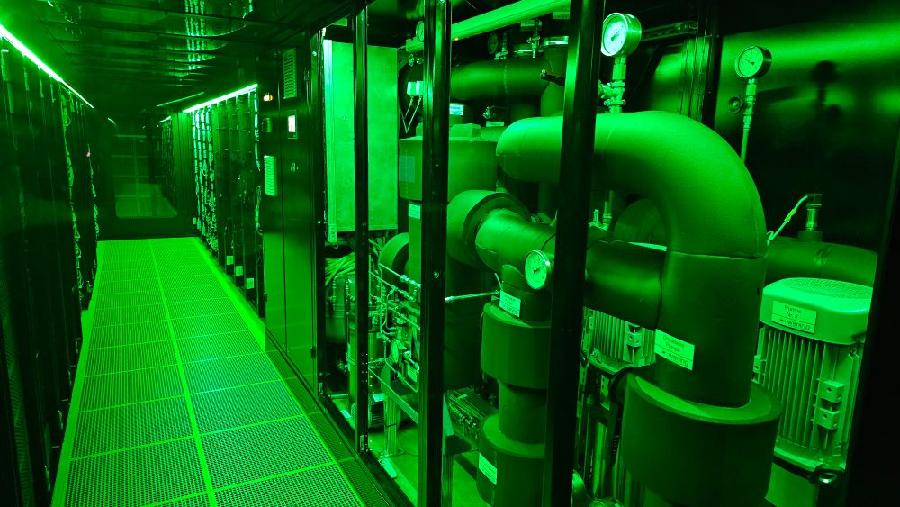 Teil des Kühlsystems in einem Hochleistungsrechner (hier HoreKa: Hochleistungsrechner Karlsruhe) in grünem LED-Licht beleuchtet. 