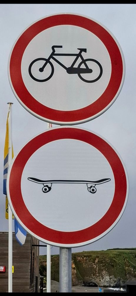 Übereinander angeordnete Verbotsschilder. 
Oben:Verbot für Radfahrende.
Unten: Verbot für Skateboardfahrende.