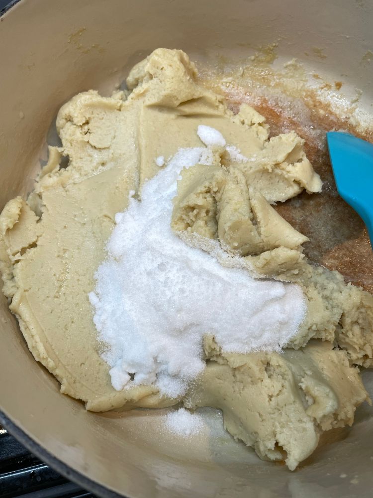 lotus paste mixture in a pot, with sugar being added