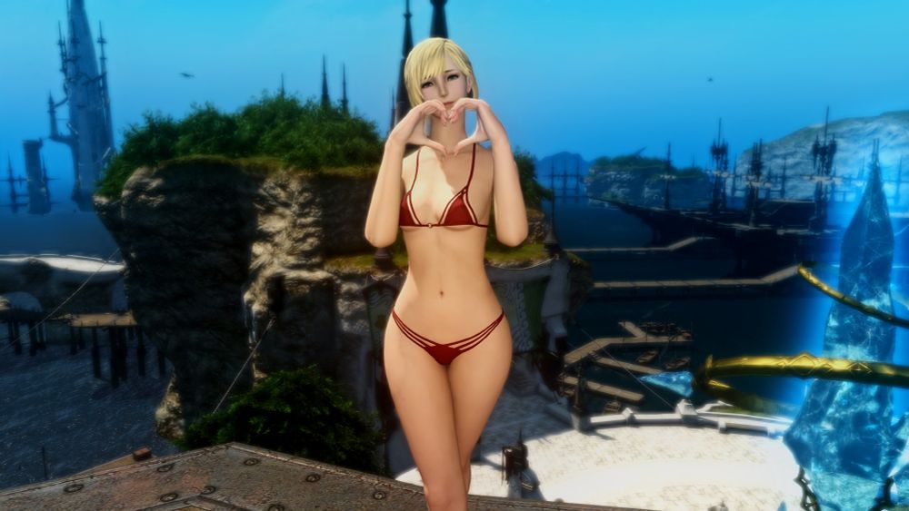 A blonde haired woman is making a heart shape with her hands while wearing a cute bikini.