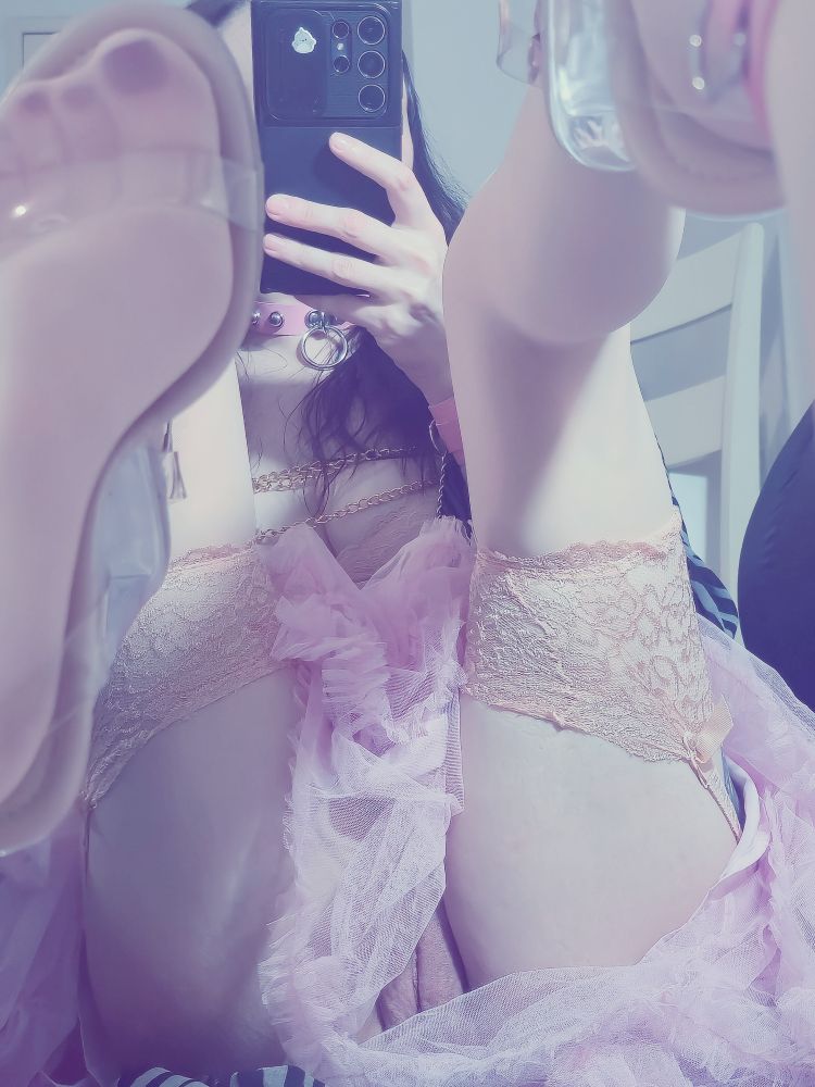 Ursula sitting in front of her mirror with her shoes and feet up pressed against the mirror.

She isnt wearing panties and you can see her puffy pink pussy lips. Her pink fairy skirt is gathered around her hips and falling between her legs. She is wearing stockings and a sispender belt. 