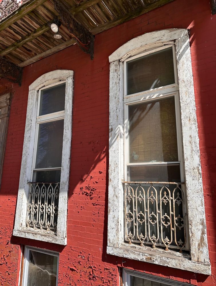 A brick building with ragged wooden windows in DC. Color