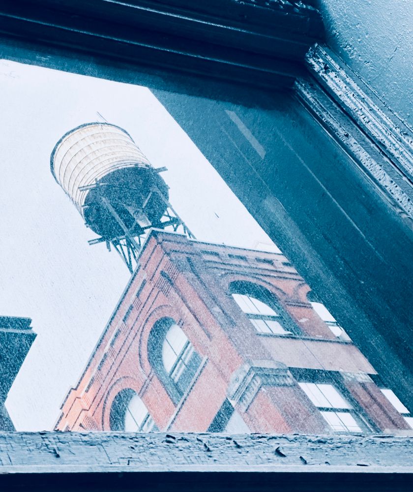 A reflection of a water tower on top of a red building in SOHO