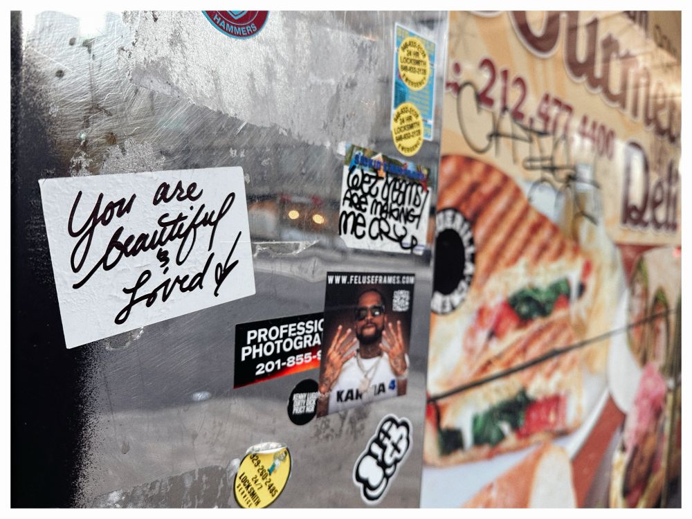 a YOU ARE BEAUTIFUL AND LOVED sticker on a bodega 