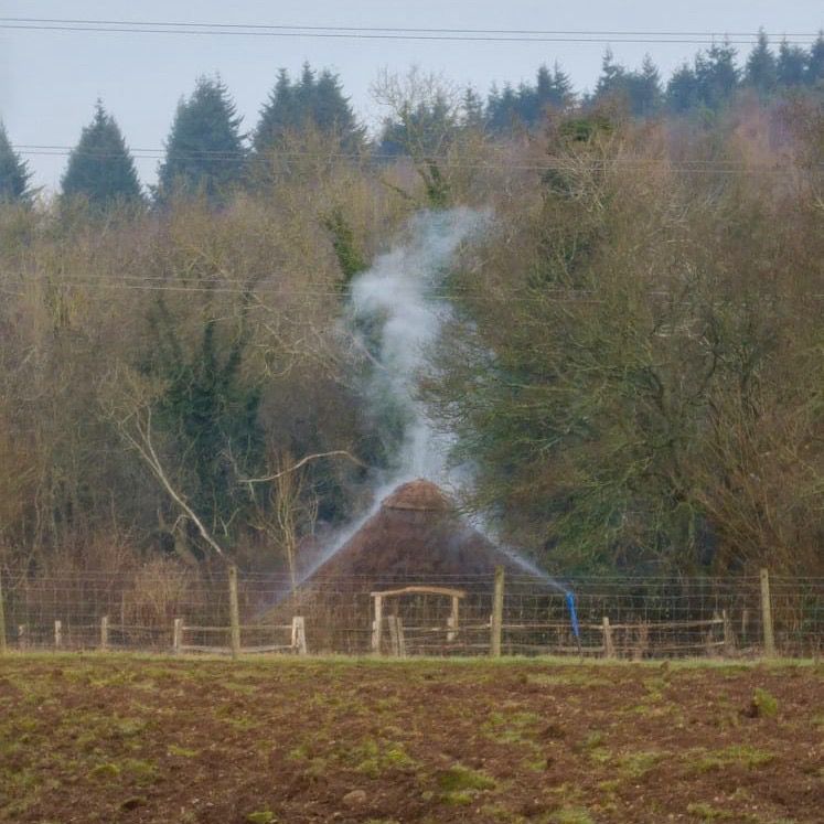 Iron Age roundhouse with smoke coming through the roof