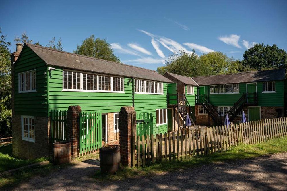 A reconstructed furniture factory from High Wycombe. It is L shaped with two floors painted green.
