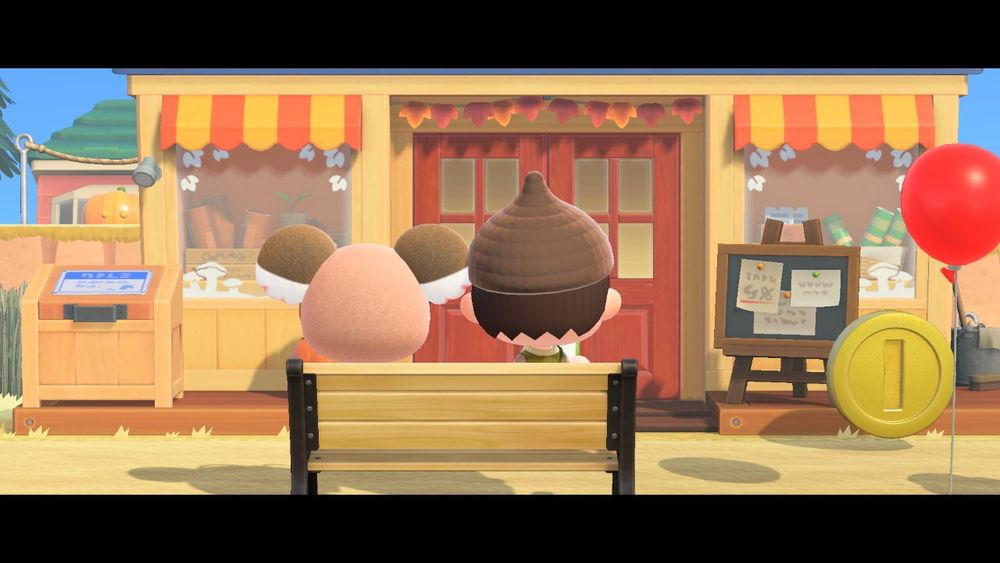 Melba and I sitting on a bench right in front of Nook's store. There's a red balloon and a coin. 
