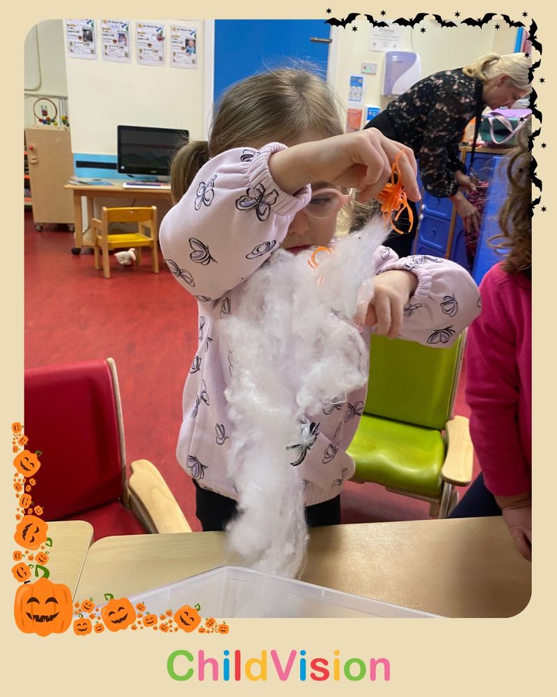 Young child playing with toy cobweb