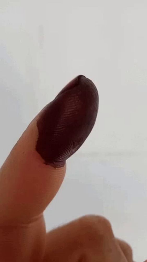 a close up of a person 's finger with black paint