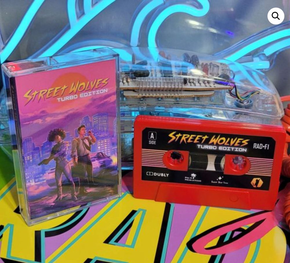 Picture of a cassette case with the Street Wolves cover and a USB drive that looks like a tape. In the background it’s 80s themed.